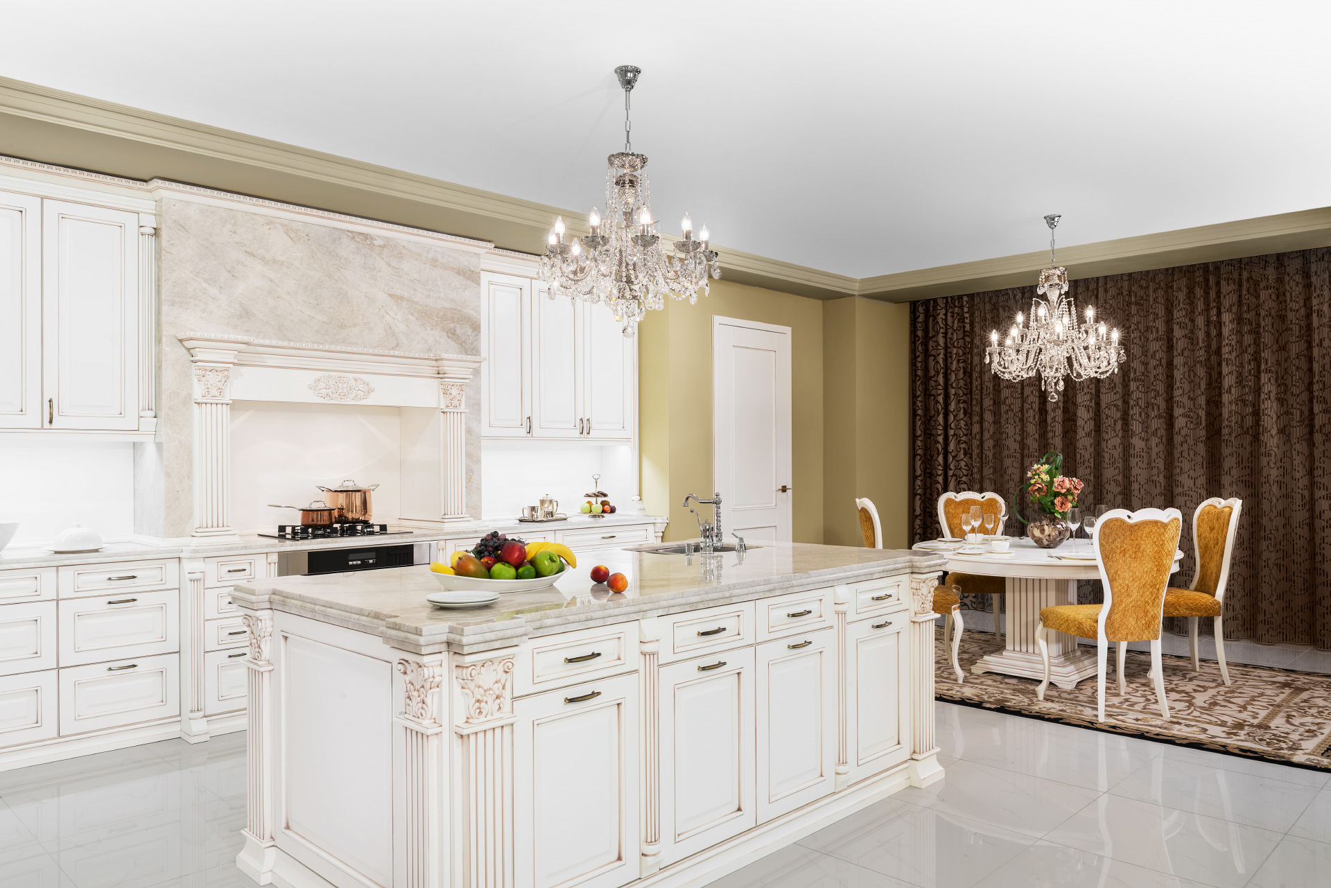 Elegantní bílá kuchyně Royal a charakteristické vysoce zdobné římsy a sloupky.